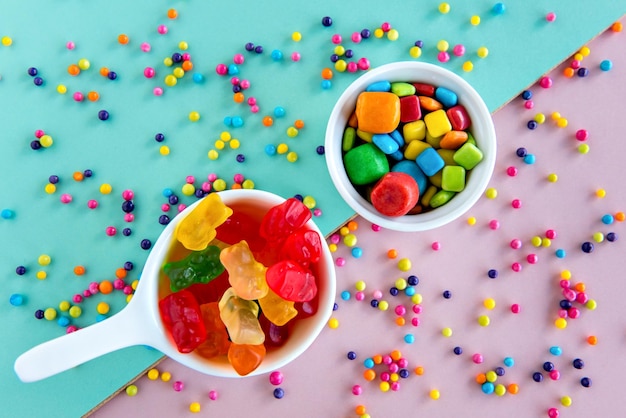 Candy and colored gum on a green and pink background happy children's day