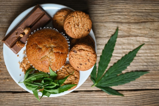 Cannabis food cookies with cake chocolate cannabis leaf marijuana herb on wooden and dark background delicious sweet dessert cookie with hemp leaf plant THC CBD herbs food snack and medical