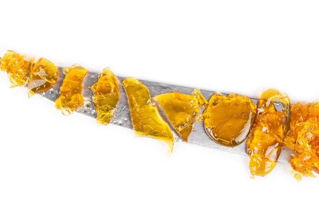 Cannabis wax with a high content of thc on the blade of a knife isolated on a white background