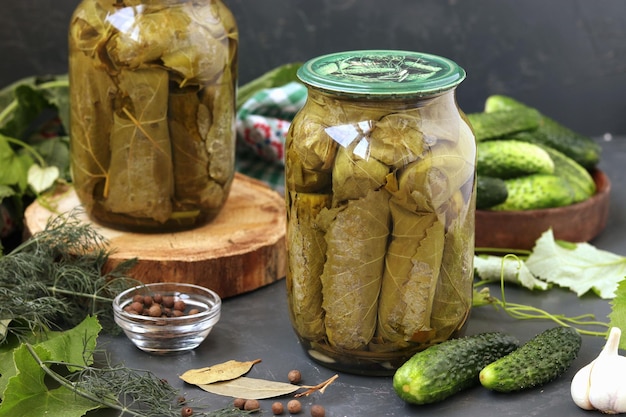 Canned cucumbers in grape leaves in glass jars on a dark background Harvest for the winter