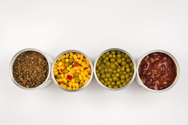 Canned food on white background. Green pea, beans, corn, lentils.