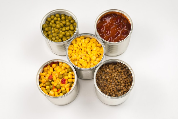 Canned food on white background Green pea beans corn lentils