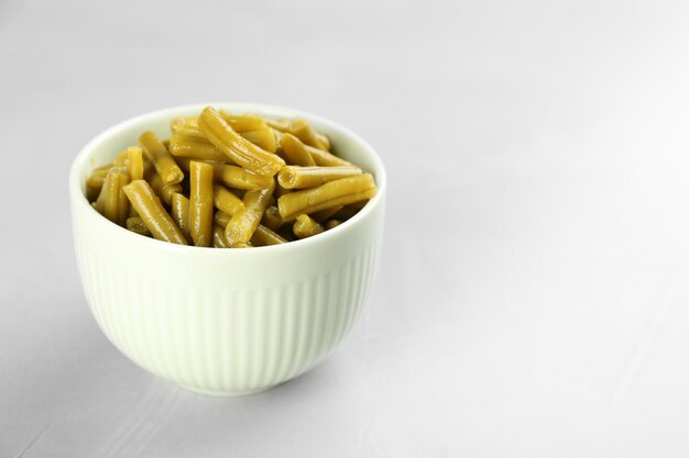 Canned green beans on light grey table Space for text