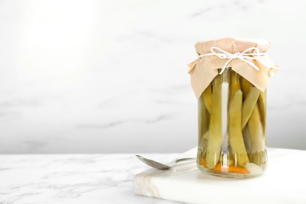 Canned green beans on white marble table Space for text