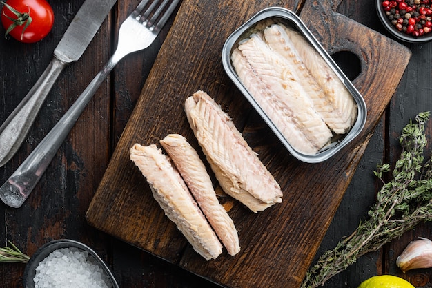 Canned Mackerel  fillet, fish preserves, on wooden cutting board, on old dark  wooden table