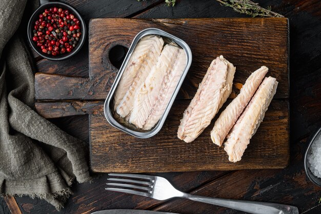 Canned Mackerel  fillet, fish preserves, on wooden cutting board, on old dark  wooden table