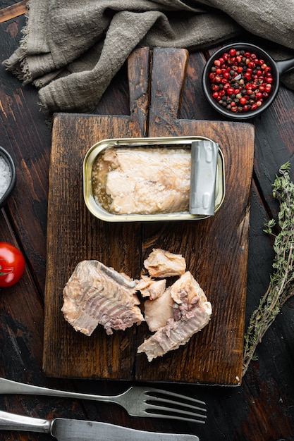 Canned salmon, fish preserves, on wooden cutting board, on old dark  wooden table