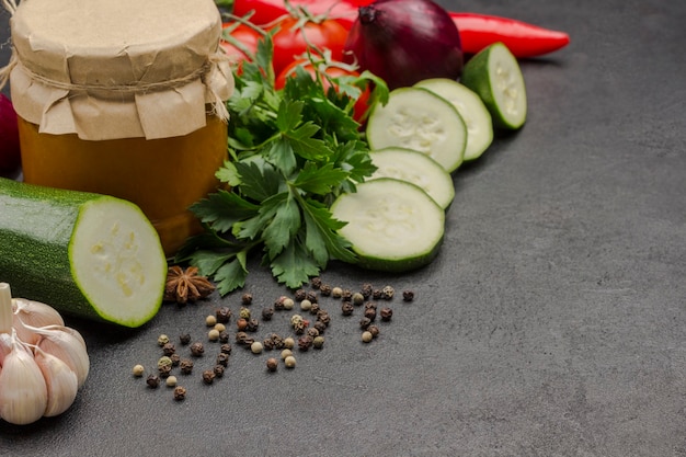 Canned squash spread in glass jar. Raw vegetables and spices: carrots garlic, onions tomatoes, peppercorn. Healthy winter nutrition. Fermentation Products. . Copy space