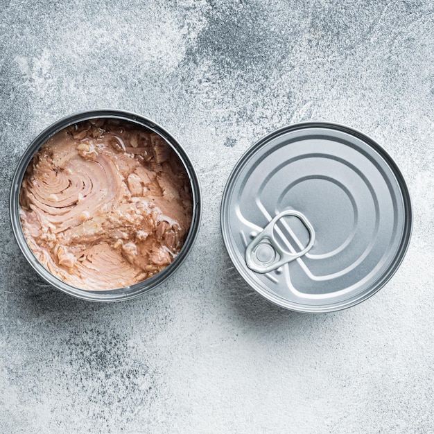 Canned Wild Yellowfin Tuna in tin can on gray background top view flat lay square format