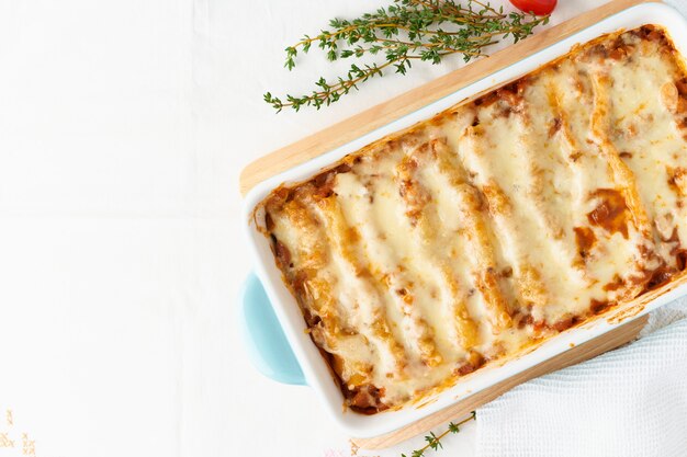 Cannelloni pasta with filling of ground beef, tomatoes, baked with bechamel tomato sauce