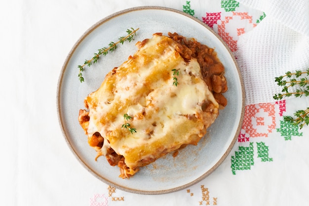 Cannelloni pasta with filling of ground beef, tomatoes, baked with bechamel tomato sauce