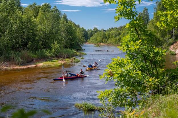 Canoeing on forest river. Friends driving with kayak on forest river. active pastime and entertainment in summer. Several people team inflatable canoes rafting in calm waters with nice surrounding