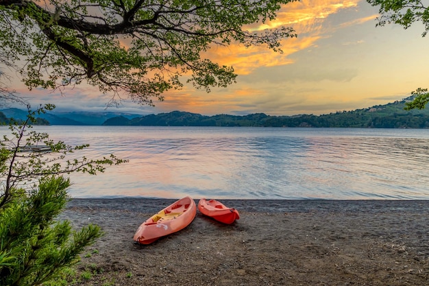 Canoes beside lake at sunset