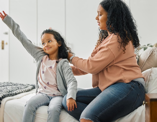 Cant forget to brush your hair Shot of a young mother brushing her daughters hair at home