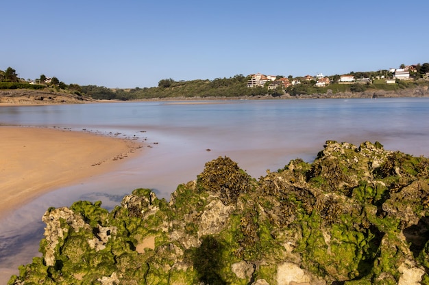 Cantabrian sea beach in the middle of nature with the sea entering the shore and eroded rock in the foreground