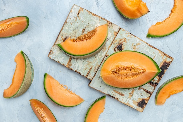 Cantaloupe melon whole and slice of japanese melons orange melon with seeds on light background place for text top view