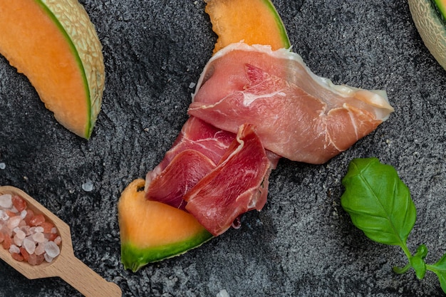 Cantaloupe melon with ham prosciutto jamon Traditional Spanish and Italian appetizer banner menu recipe top view