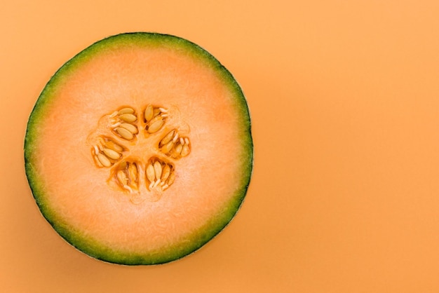 Cantaloupe Orange Melon Sliced in Half on Pastel Background