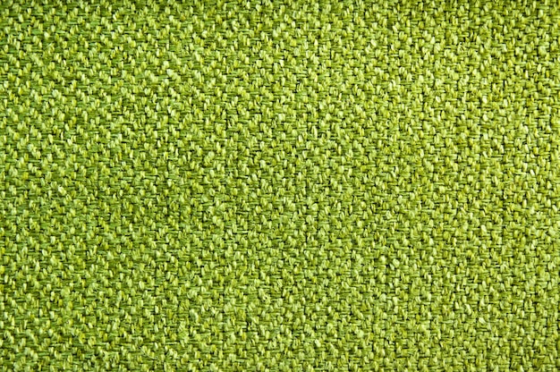 The canvas of the woolen fabric is bright green. Top view, fabric texture.