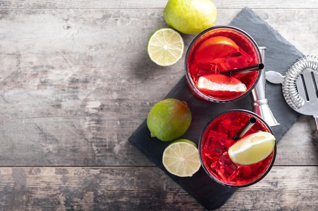 Cape Codder cocktail with vodka cranberry juice and lime on wooden table