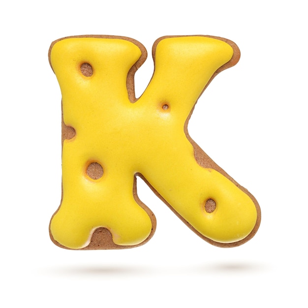 Capital letter K yellow homemade gingerbread biscuit isolated on white background