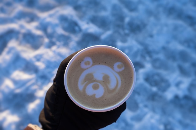 Cappuccino paper cup. Delicious morning coffee to take away. Top view of an art drawing of a bear