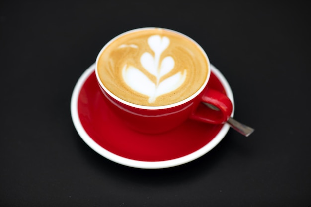 Cappuccino in red cup cappuccino coffee in a beautiful glass on the table