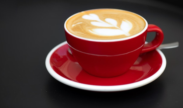 Cappuccino in red cup cappuccino coffee in a beautiful glass on the table