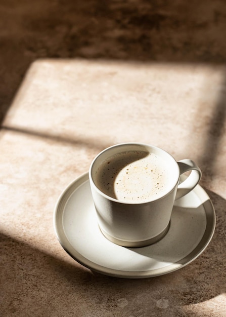 Cappuccino with foam in hard light with beautiful shadows isolated Coffe break concept Copy space