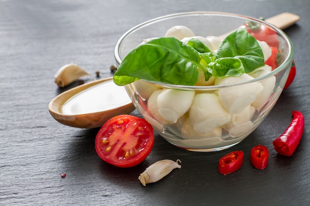 Caprese salad ingredients on dark stone background