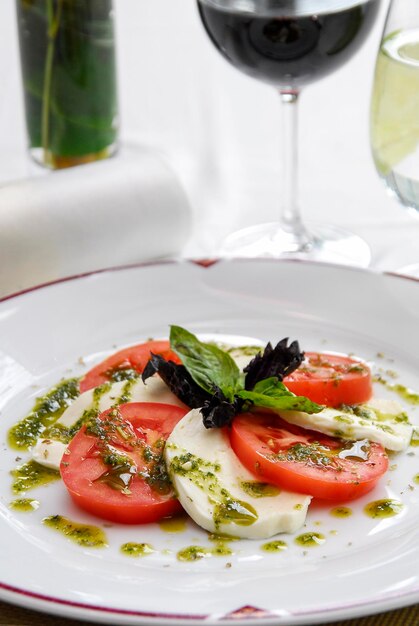 caprese salad with ripe tomatoes and mozzarella cheese with fresh basil leaves and dressing food