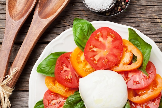 Photo caprese salad with tomatoes basil and mozzarella