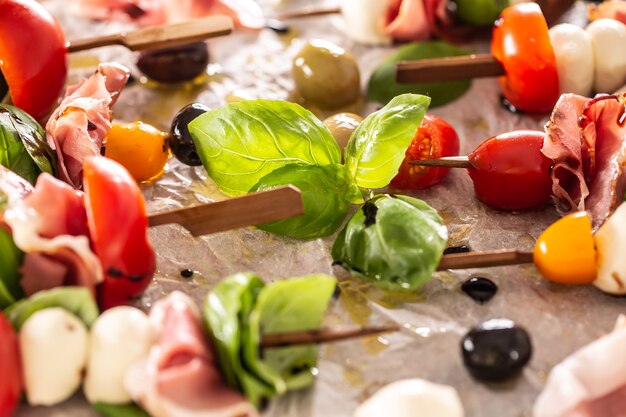 Caprese skewers italian or mediterranean appettizer tomatoes mozzarella olives and prosciutto