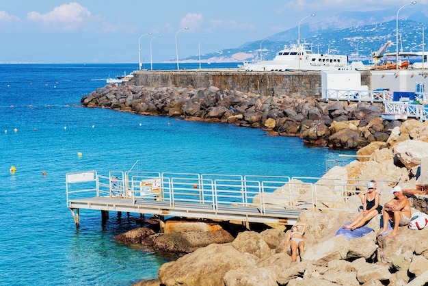 Capri, Italy - October 3, 2017:  People on Rocky beach on Capri Island town at Naples in Italy. Landscape with Blue Mediterranean Sea at Italian coast. Anacapri in Europe. Amalfi and Solaro mountain