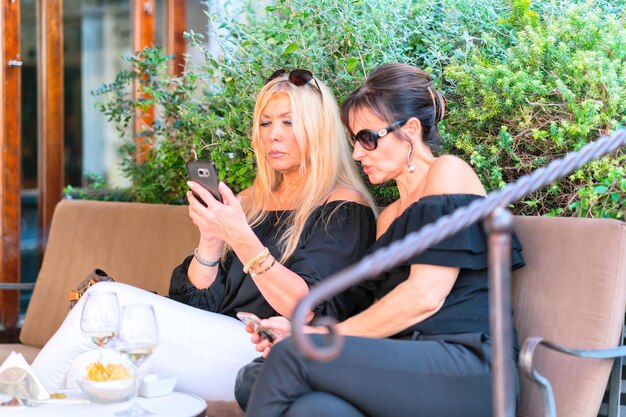 Photo capri, italy - october 3, 2017: women relaxing at the restaurant on capri island, italy