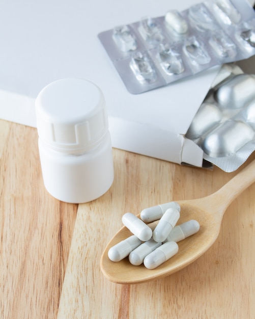 Capsule medicine in a ladle wooden on pattern table,