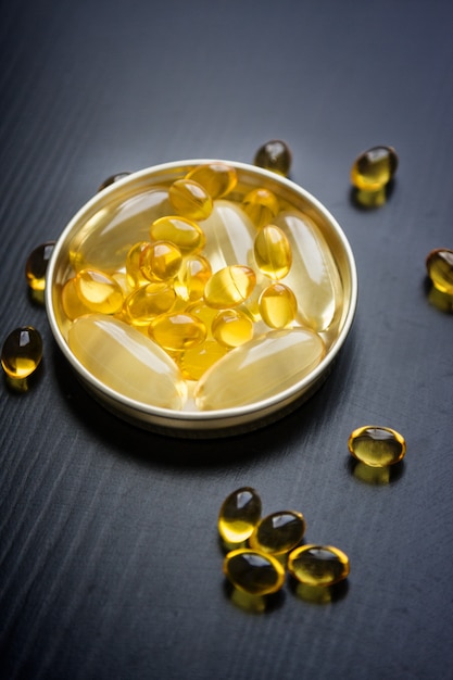 Capsules of fish oil in gold cup 