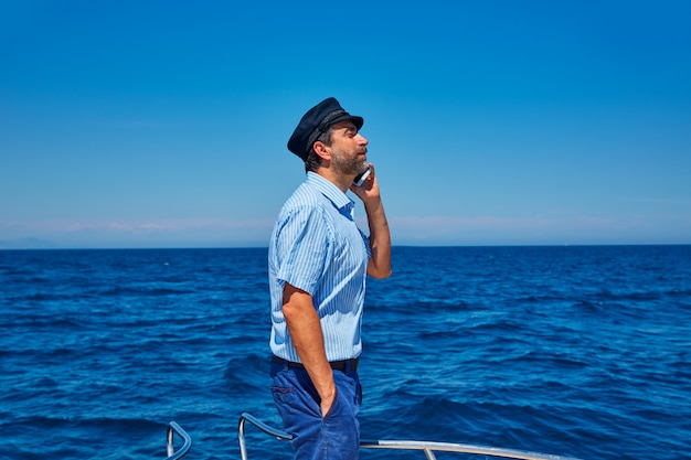 Captain cap sailor man talking mobile phone boat