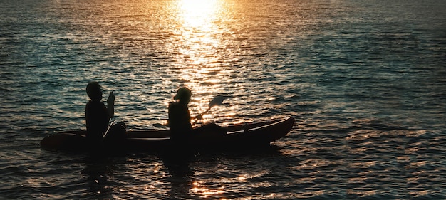 Capture romantic moment with love from silhouette a couple on boat with sunset