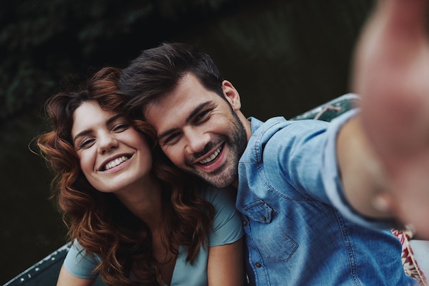 Capturing happy moments. Self portrait of beautiful young couple looking at camera 