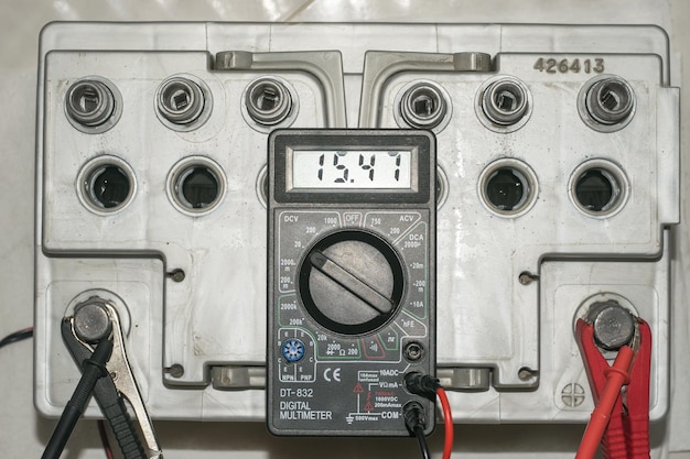 Car battery charging Gray battery with caps unscrewed charger cables connected