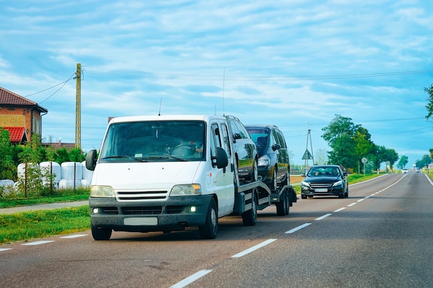 Car carrying trailer with new vehicles at the asphalt road in Slovenia.