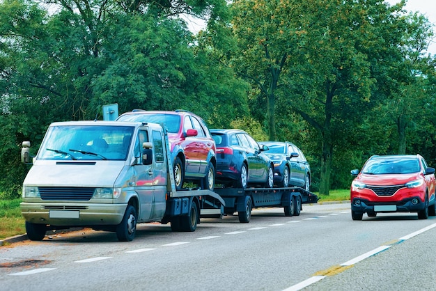 Car carrying trailer with new vehicles on the asphalt road, Slovenia.