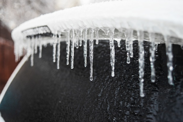 Car covered with ice and icicles after freezing rain Bad frosty weather Ice storm cyclone Winter snowy scenes