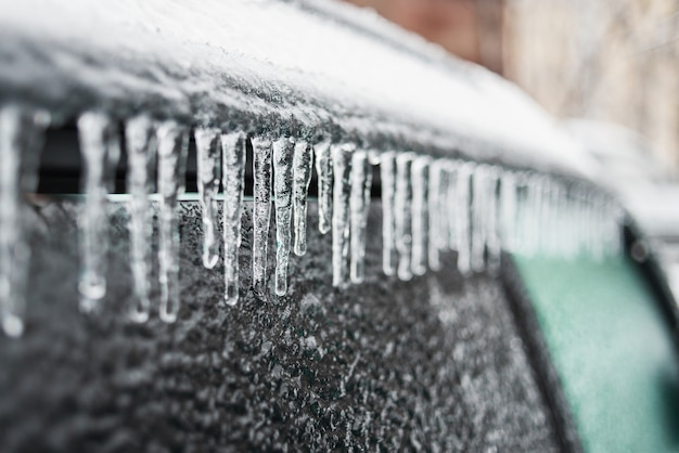 Car covered with ice and icicles after freezing rain Bad winter weather ice storm Winter frosty scenes