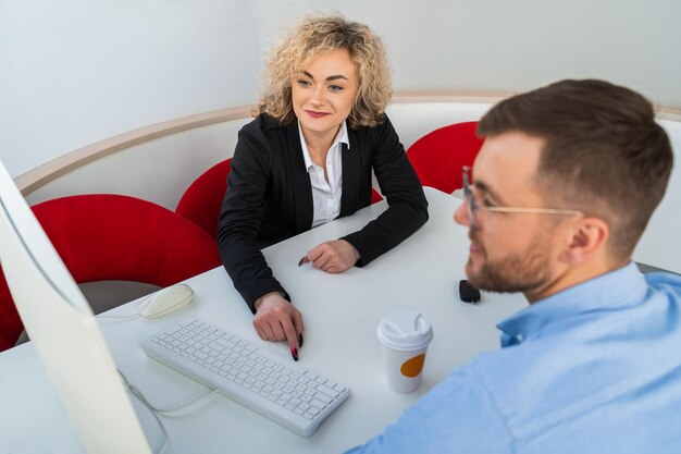 Car dealership manager with client at computer