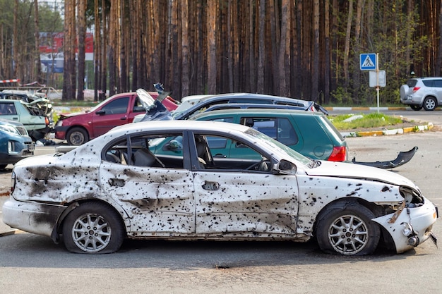 A car destroyed by shrapnel from a rocket that exploded nearby Irpensky automobile cemetery Consequences of the invasion of the Russian army in Ukraine Destroyed civilian vehicle