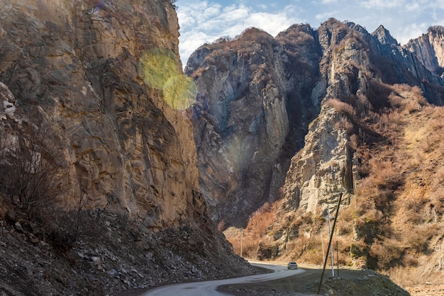 Car on dirt road through a mountain gorge