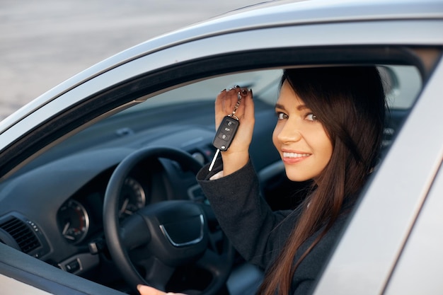 Car driver woman smiling showing new car keys