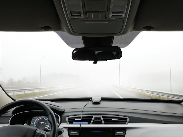 The car goes fast on the road in the fog, view from the passenger compartment